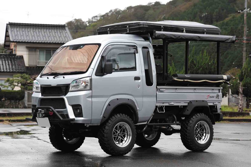 White Hijet Truck with roof rack, jerry can, and outdoor expedition setup